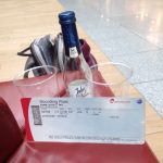 Sektpiccolo mit zwei Gläsern auf dem Gepäck