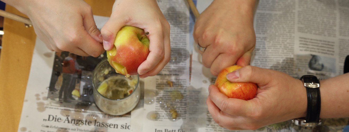 Teilnehmerinnen bei der praktischen Übung mit Holzstab und Apfel